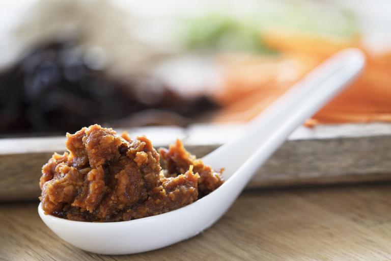 a soup spoon filled with red miso paste