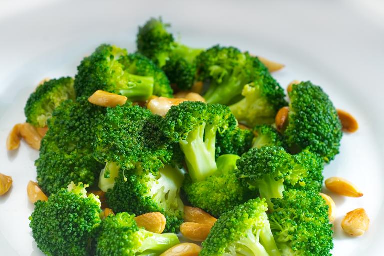 a bowl of broccoli and chopped nuts